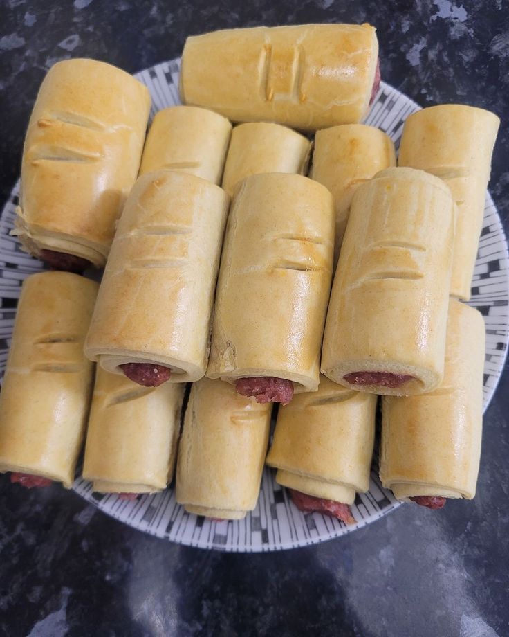 Plate stacked with freshly baked golden sausage rolls