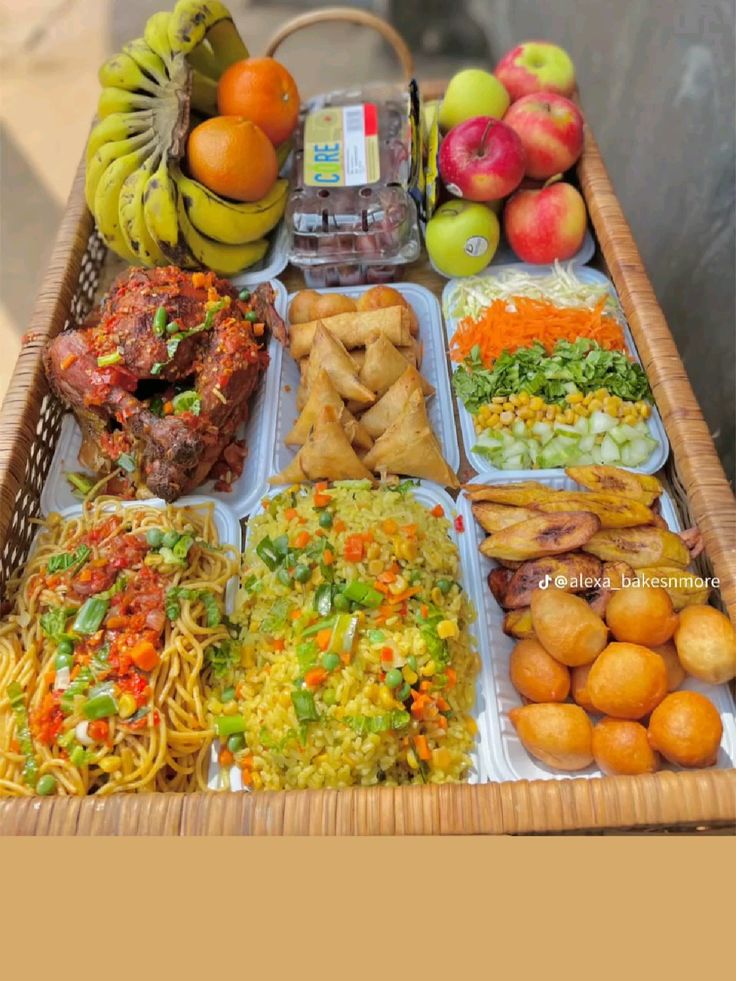 Celebration food tray with jollof rice, noodles, samosa, puff puff, plantain and fresh fruit