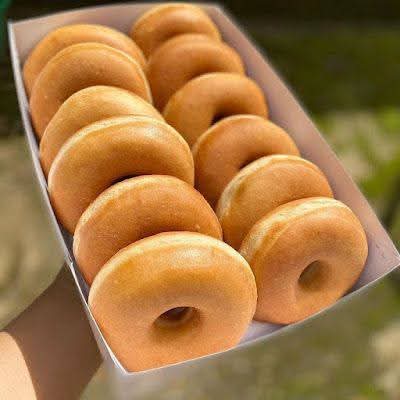 Box of freshly fried golden ring doughnuts